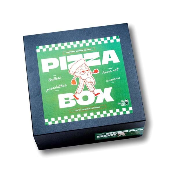 De luxe verpakking van de Big Green Egg Pizza Box. De doos is donkerblauw van kleur. Op de deksel zit een grote groene sticker met aan de boven- en onderkant een strook met groen-witte blokjes. Met grote witte letter staat de tekst 'Pizza Box. Tussen de twee woorden in loopt een fluitende pizzapunt met armpjes en beentjes.