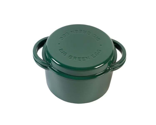 Een ronde gietijzeren Dutch Oven van Big Green Egg in een donkergroene kleur. De pan heeft een stevig deksel met het logo "Big Green Egg" erop gegraveerd. De handgrepen aan zowel de pan als het deksel zijn stevig en geïntegreerd in het ontwerp. Deze pan is geschikt voor gebruik op de barbecue of in de oven en heeft een inhoud van 4 liter. Ideaal voor het bereiden van stoofschotels, soepen of andere gerechten. Het ontwerp is functioneel, robuust en afgewerkt met een glanzende geëmailleerde laag.