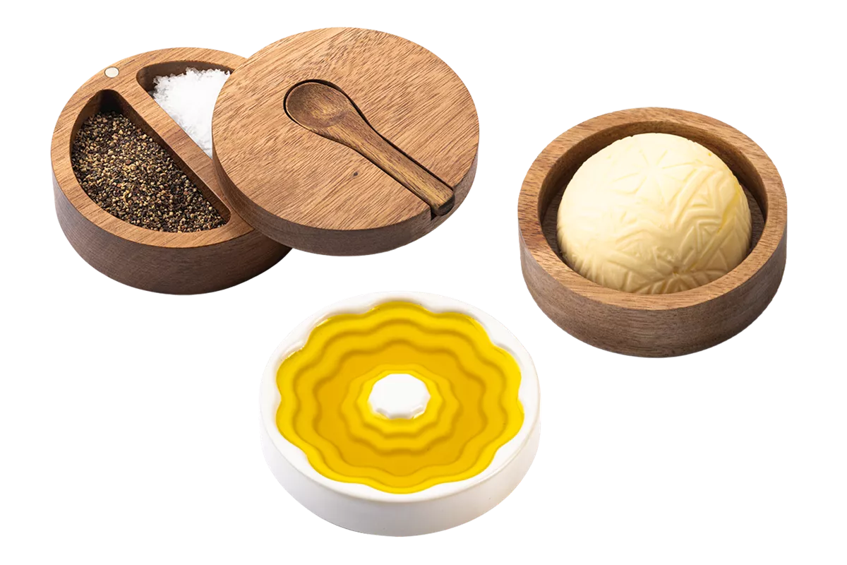 3-delige set van Style de Vie bestaande uit: een rond acaciahouten zout- en peperbakje bestaande uit 2 vakjes met een dekseltje waarin een uitsparing zit voor een acaciahouten lepeltje, een acaciahouten boterbakje en een wit, keramieken schaaltje voor olijfolie.