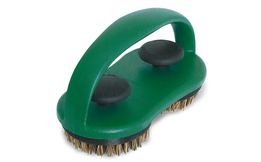 Een handborstel van Big Green Egg, ontworpen voor het reinigen van barbecuegrillroosters. De borstel heeft een stevige groene kunststof basis met een geïntegreerd handvat voor een comfortabele grip. Onder de basis bevinden zich twee ronde borstelkoppen met borstelharen van natuurlijke boomvezels. Aan de bovenkant zijn twee zwarte knoppen zichtbaar die helpen om de borstelkoppen stevig vast te zetten. Het compacte ontwerp maakt het een praktische tool.