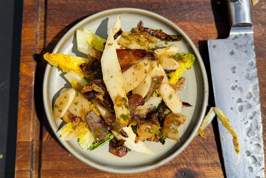 Gegrilde witte asperges van de kamado met little gem & zwarte knoflook