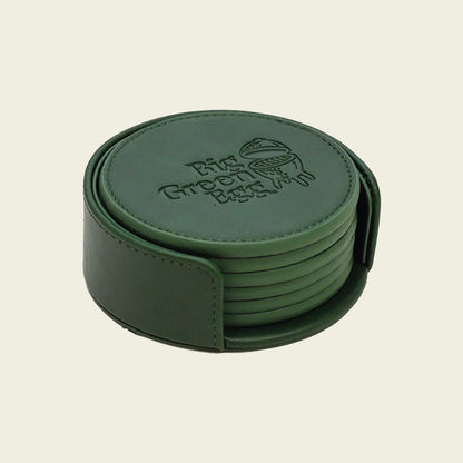 Leren onderzetters van Big Green Egg in de kleur groen. De 6 onderzetters hebben een luxe uitstraling en zitten in een groene houder met opening aan de voorkant zodat de onderzetters er makkelijk uitgepakt kunnen worden. Bovenop iedere onderzetter is het logo van Big Green Egg gedrukt. Aan de rand hebben de onderzetters rondom een stiknaad. Dit geldt ook voor de houder.