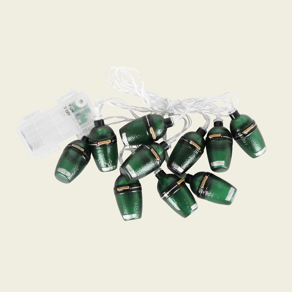 String met 10 LED lichtjes van Big Green Egg. Ieder lichtje is omhuld met een mini Big Green Egg kamado. De lichtjes zijn met elkaar verbonden door een transparant snoer en heeft een transparante doosje met een aan en uit schakelaar voor de batterijen.