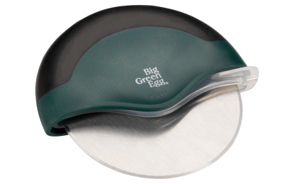De Big Green Egg pizza cutter die onderdeel uitmaakt van de Pizza Box. De pizzasnijder bestaat uit een rond roestvrijstalen mes, dat voor de helft wordt bedekt door een halfrond kunststof handvat Het bovenste gedeelte van het handvat is van een zwart antislip materiaal gemaakt en de rest van het handvat is groen van kleur. Onderaan staat gecentreerd het Big Green Egg logo in witte opdruk. Vanuit de zijkant van het handvat kan een transparante beschermkap om het mes heen worden getrokken.