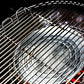 De binnenkant van een Big Green Egg barbecue. Een zilverkleurige aluminium druippan ligt in het midden, geplaatst op een convEGGtor (een keramisch hitteschild). Boven de druippan is een metalen grillrooster bevestigd. De druippan is bedoeld om vet en sappen op te vangen tijdens het barbecueën, terwijl de convEGGtor zorgt voor indirecte hitte. Het geheel is klaar voor gebruik, met gloeiende kooltjes zichtbaar onder de convEGGtor. De setting benadrukt een efficiënte en schone manier van koken.