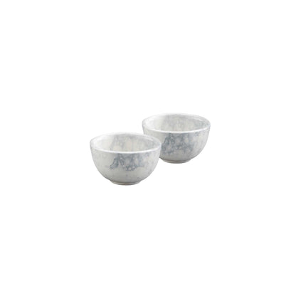 Set van 2 handgemaakte aardewerken schaaltjes van ieder 11 cm doorsnede. De schaaltjes zijn roomwit van kleur en hebben een patroon van luchtbellen in verschillende grijstinten. De schaaltjes zijn van opzij gefotografeerd, tegen een witte achtergrond.