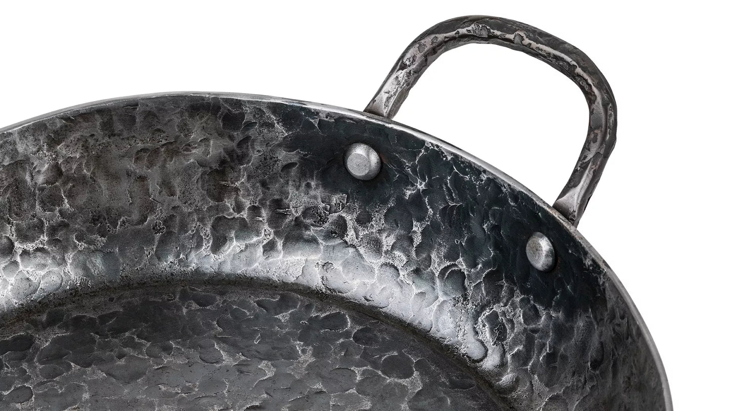 Een close-up van het gepopnagelde handvat vanaf de binnenkant van de pan gezien.