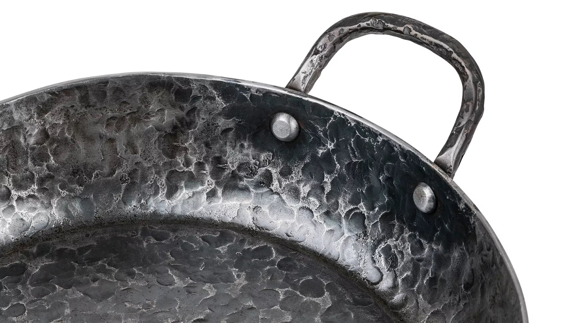 Een close-up van het gepopnagelde handvat vanaf de binnenkant van de pan gezien.