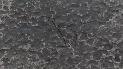 Een close-up van het het beeldmerk van het merk Forged, dat aan de onderkant van de pan is ingebrand.