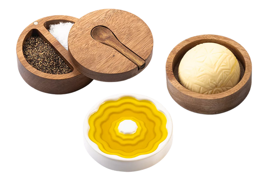 3-delige set van Style de Vie bestaande uit: een rond acaciahouten zout- en peperbakje bestaande uit 2 vakjes met een dekseltje waarin een uitsparing zit voor een acaciahouten lepeltje, een acaciahouten boterbakje en een wit, keramieken schaaltje voor olijfolie. 