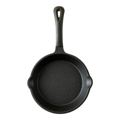 Zwarte gietijzeren skillet met schenktuiten aan beide kanten. De skillet heeft een steel die voorzien is van een ophangoog. De koekenpan is aan de voorkant van bovenaf gefotografeerd.