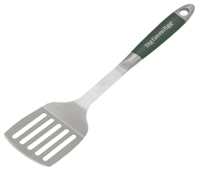 Een roestvrijstalen spatel van Big Green Egg, ontworpen voor het grillen en omdraaien van voedsel op de barbecue. De spatel heeft een brede, platte kop met sleuven, waardoor overtollig vet en vloeistof kunnen weglopen. Het handvat is ergonomisch gevormd en heeft een groene antisliplaag met het logo "Big Green Egg" erop gedrukt. Aan het uiteinde van het handvat bevindt zich een ophangoog, waardoor de spatel gemakkelijk kan worden opgeborgen. Het ontwerp is stevig, duurzaam.
